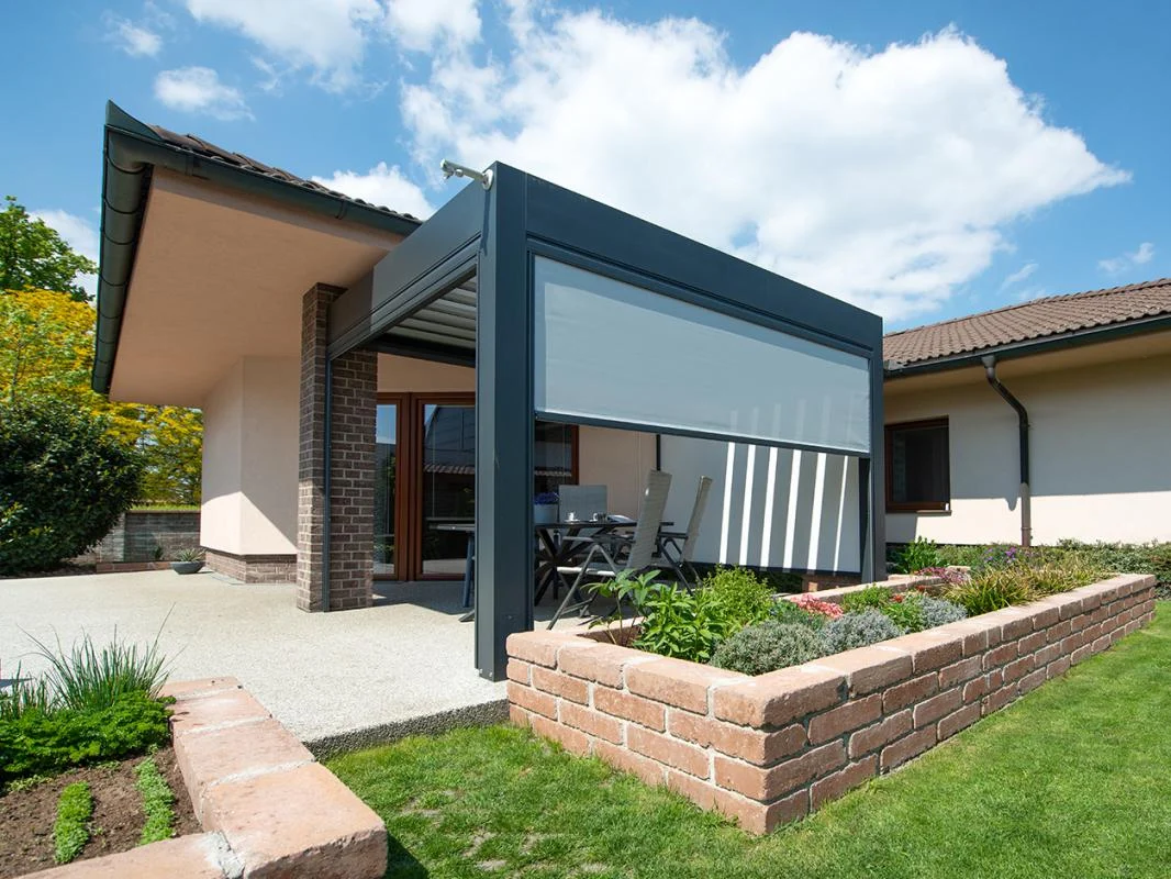 Moderner Innenhof mit einer überdachten Pergola, Gartenmöbeln und gemauerten Blumenbeeten.