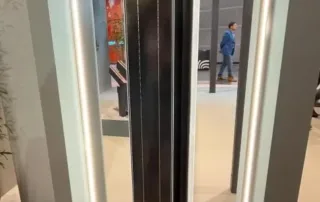 Eine hohe, rechteckige schwarze Tafel, die senkrecht in einem beleuchteten Ausstellungsrahmen steht.