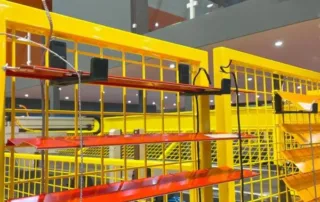 Gelber Metallzaun mit angebrachten roten Regalen und einem ZEBR-Schild im Hintergrund.